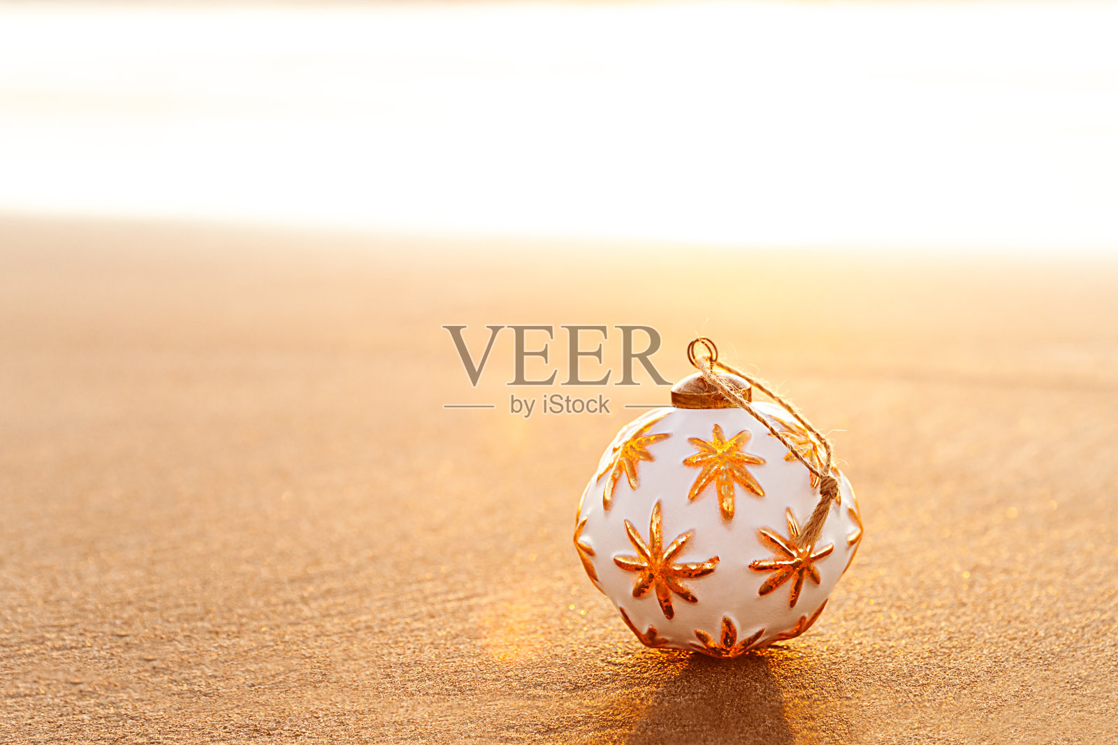 白色圣诞球在沙滩上在加利福尼亚的金色日落照片摄影图片