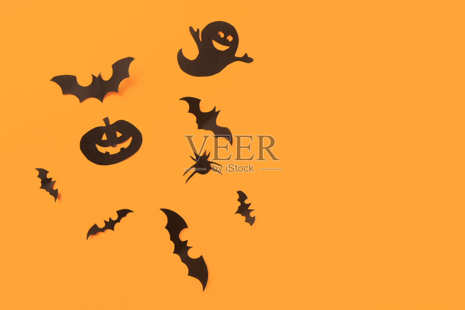 万圣节的纸装饰在橙色的背景。万圣节的概念。平铺，俯视图，拷贝空间照片摄影图片