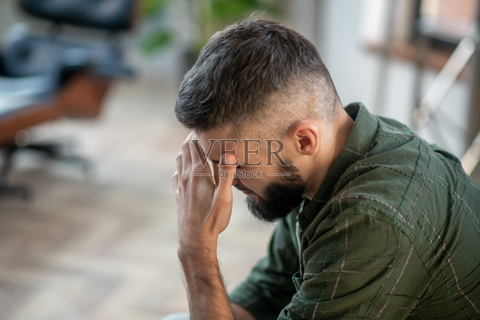 胡子男人穿着格子衬衫有强烈的头痛照片摄影图片