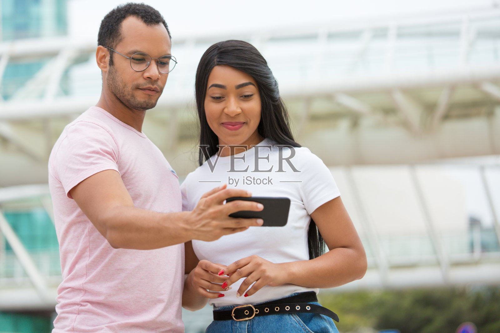 朋友们微笑着看智能手机的中间镜头照片摄影图片