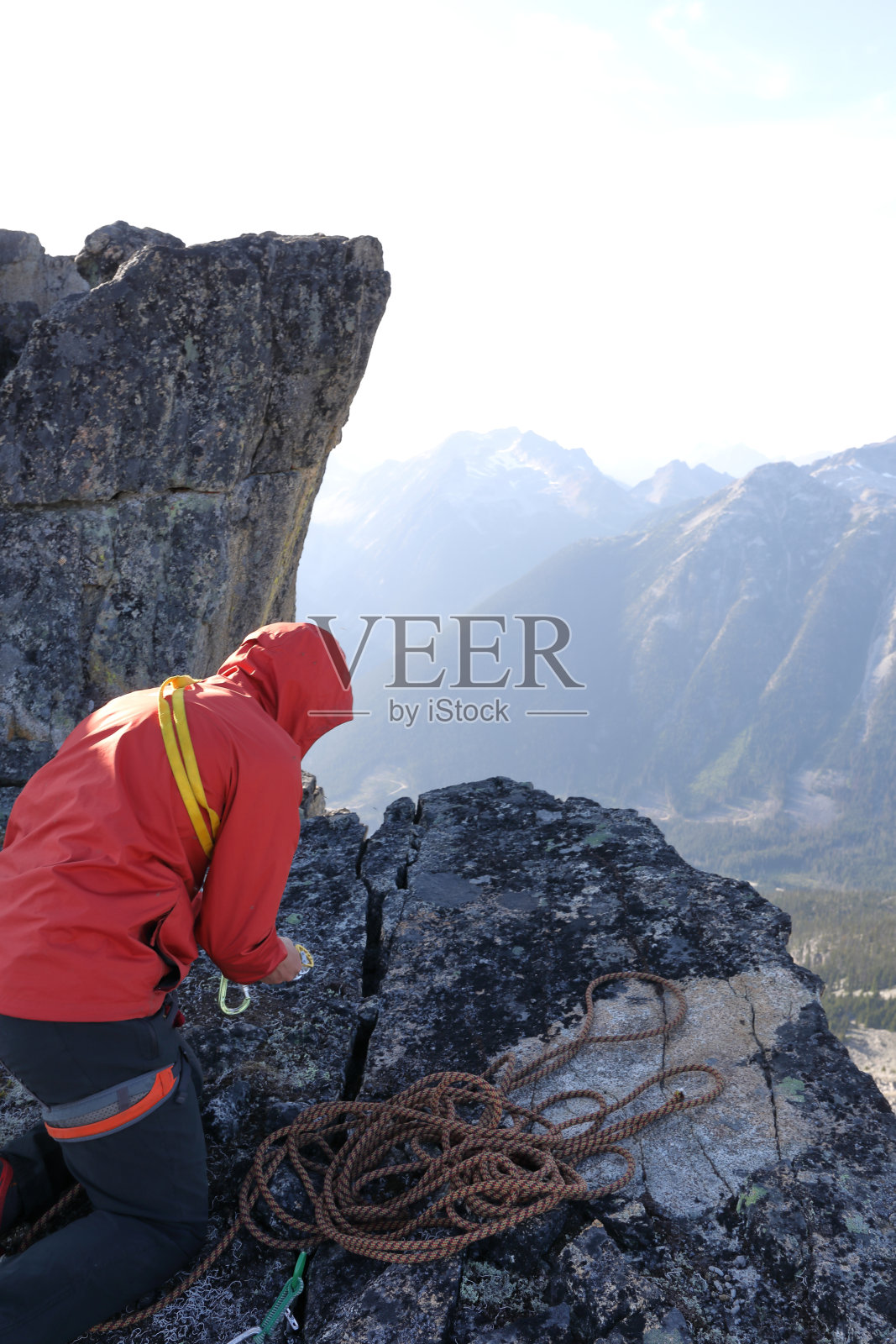 登山者在石板中调整攀登设备照片摄影图片