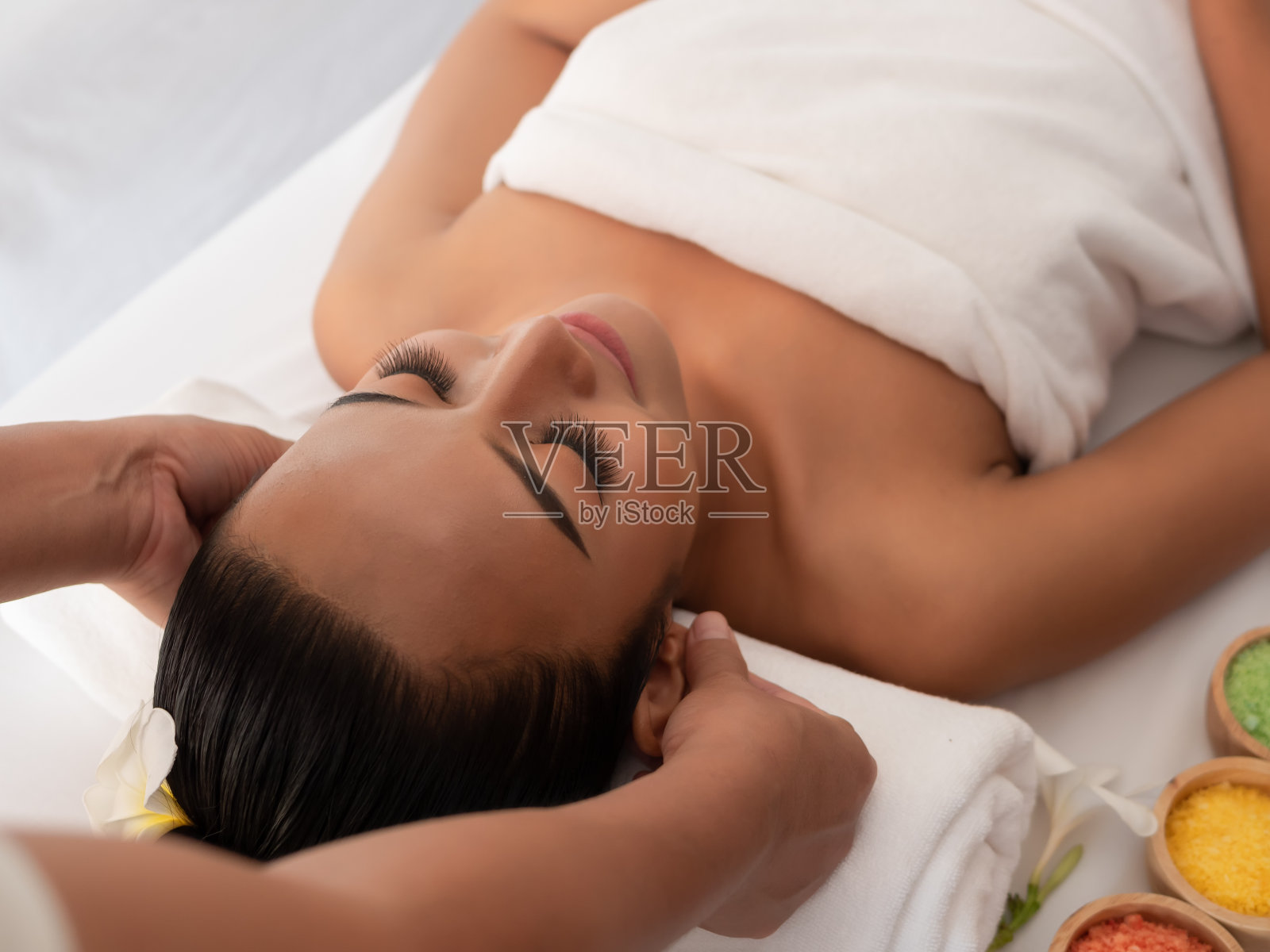 亚洲女孩是一个放松耳按摩水疗沙龙。泰式保健按摩照片摄影图片