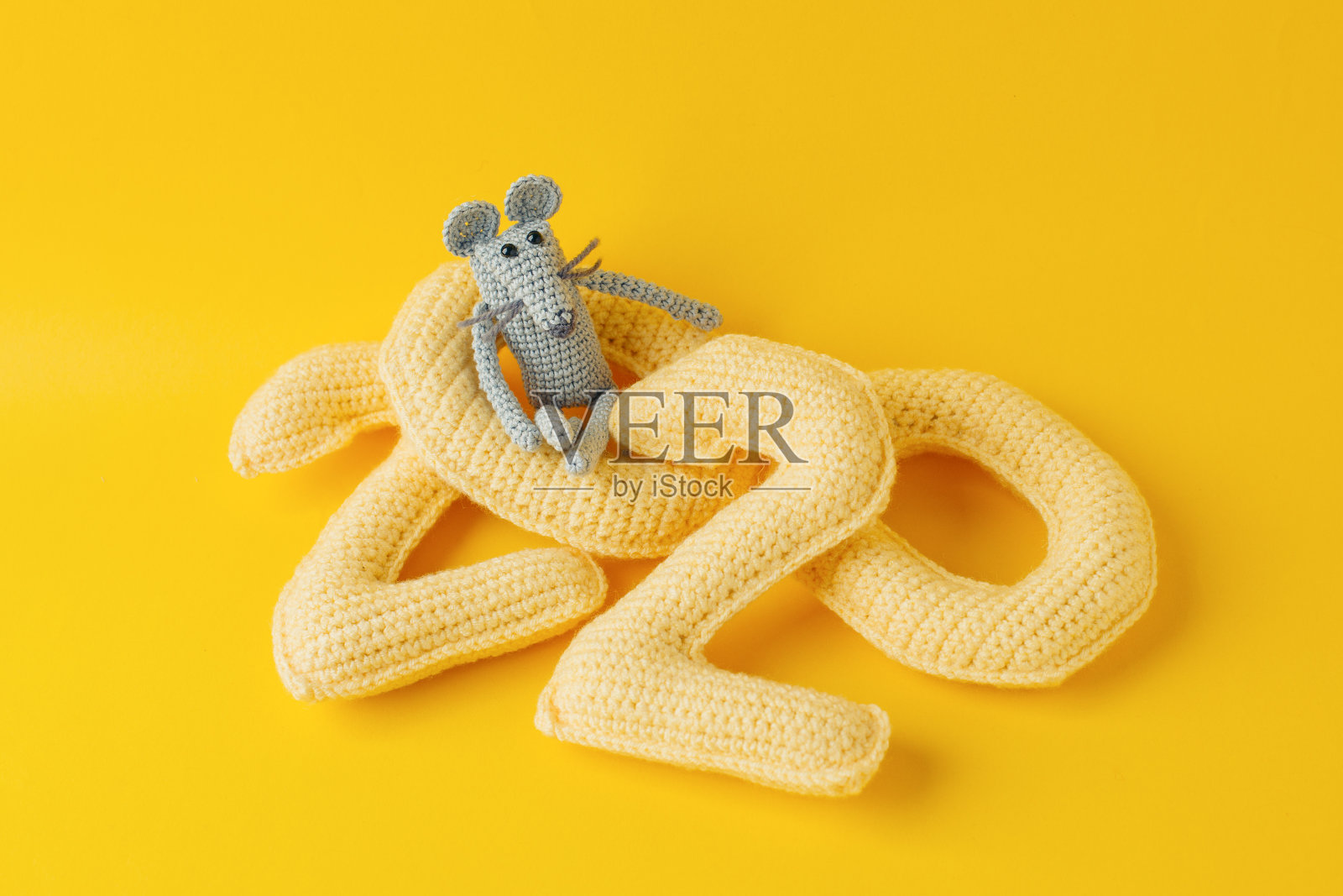 2020年新年快乐。2020号用纱线和灰色玩具鼠标编织而成，以亮黄色为背景，奶酪色。平铺，俯视图，拷贝空间照片摄影图片