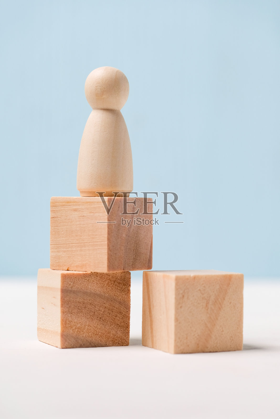 在蓝色背景上有立方体的木制人物。赢家的概念。成功之路。关闭了。照片摄影图片