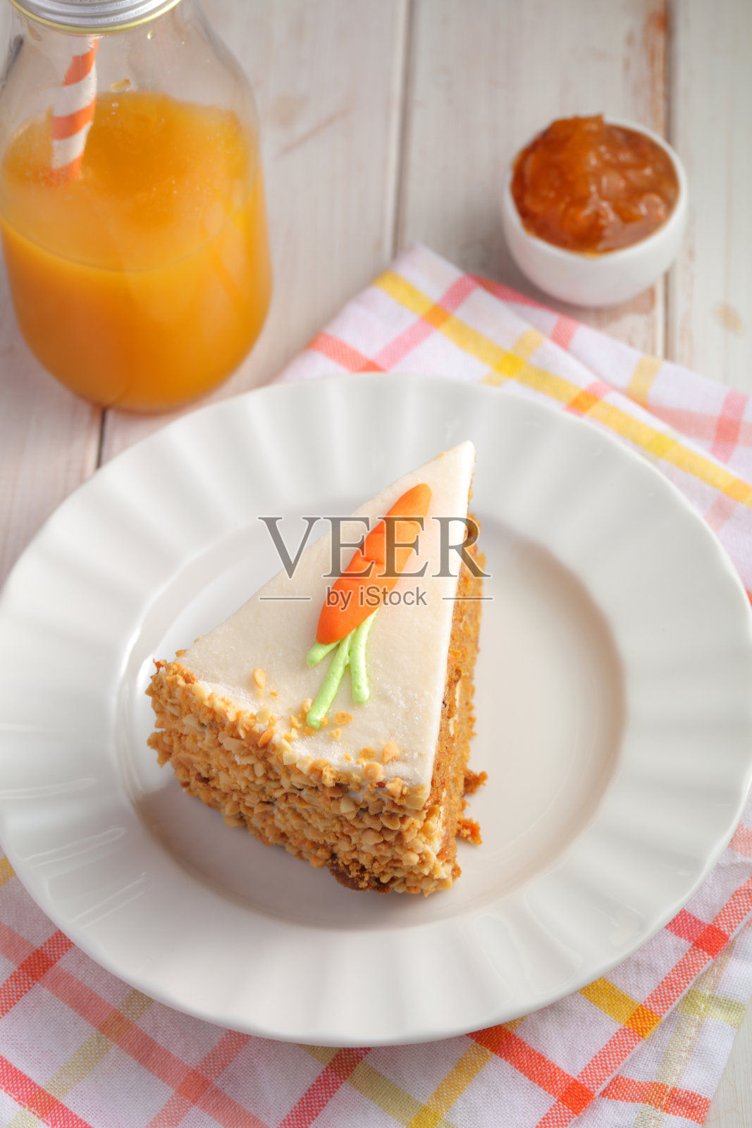 一片胡萝卜蛋糕配糖霜和杏仁糖胡萝卜在白色的背景和胡萝卜汁照片摄影图片