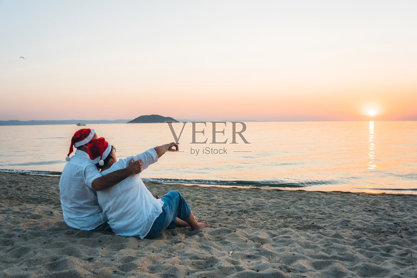 一对成熟的情侣在海滩上庆祝圣诞节照片摄影图片