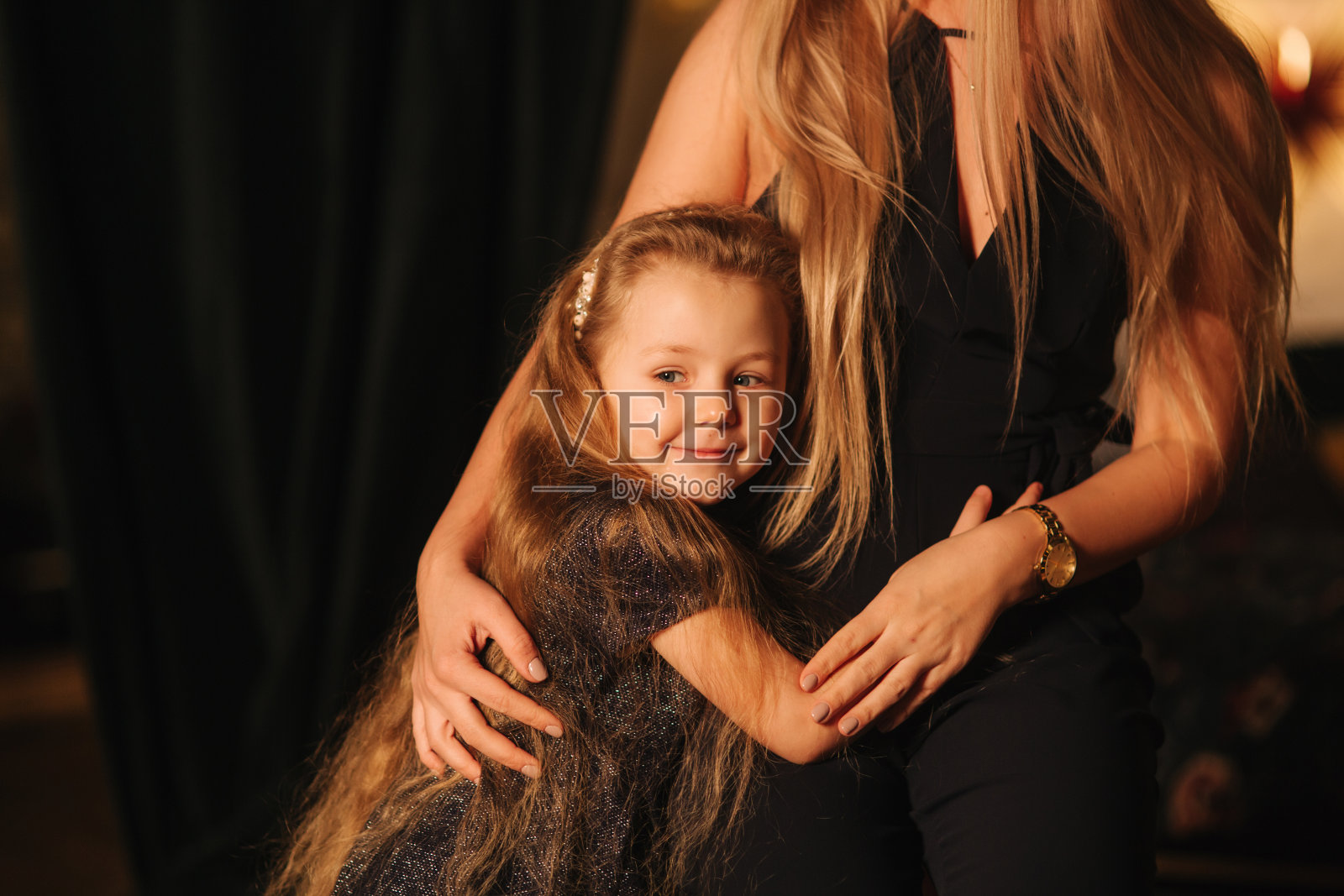 漂亮的金发妈妈和可爱的女儿在圣诞节。幸福的家庭照片摄影图片