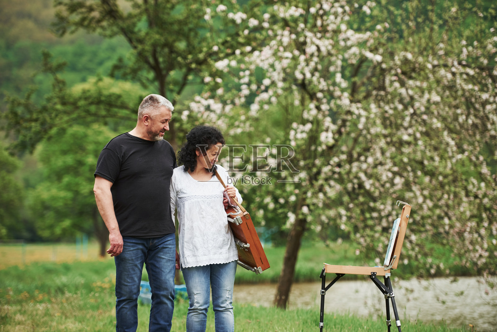 享受着油漆。一对可爱的成熟夫妇在闲暇时间在公园里散步照片摄影图片