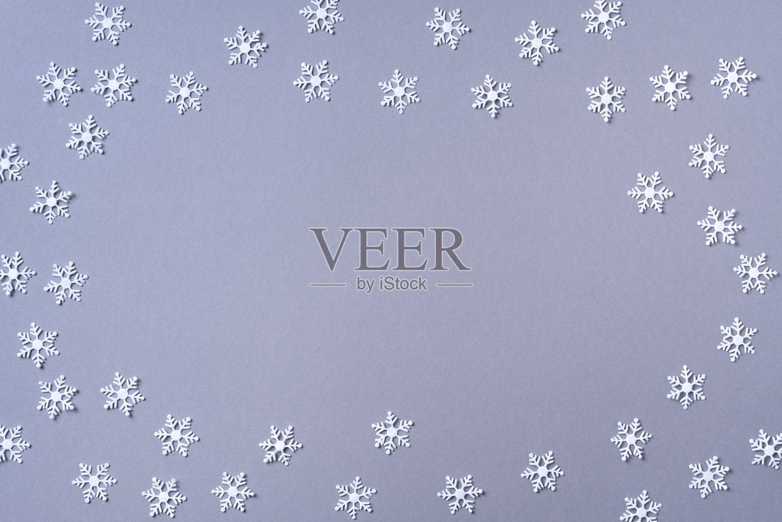 白色雪花在灰色背景上做成的冬季图案。前视图。平的。冬天的作文。圣诞节，新年的概念。照片摄影图片