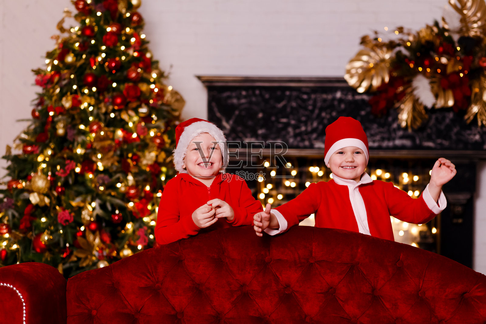 滑稽的学龄前儿童穿着红衣服在喜庆室迎接新年照片摄影图片