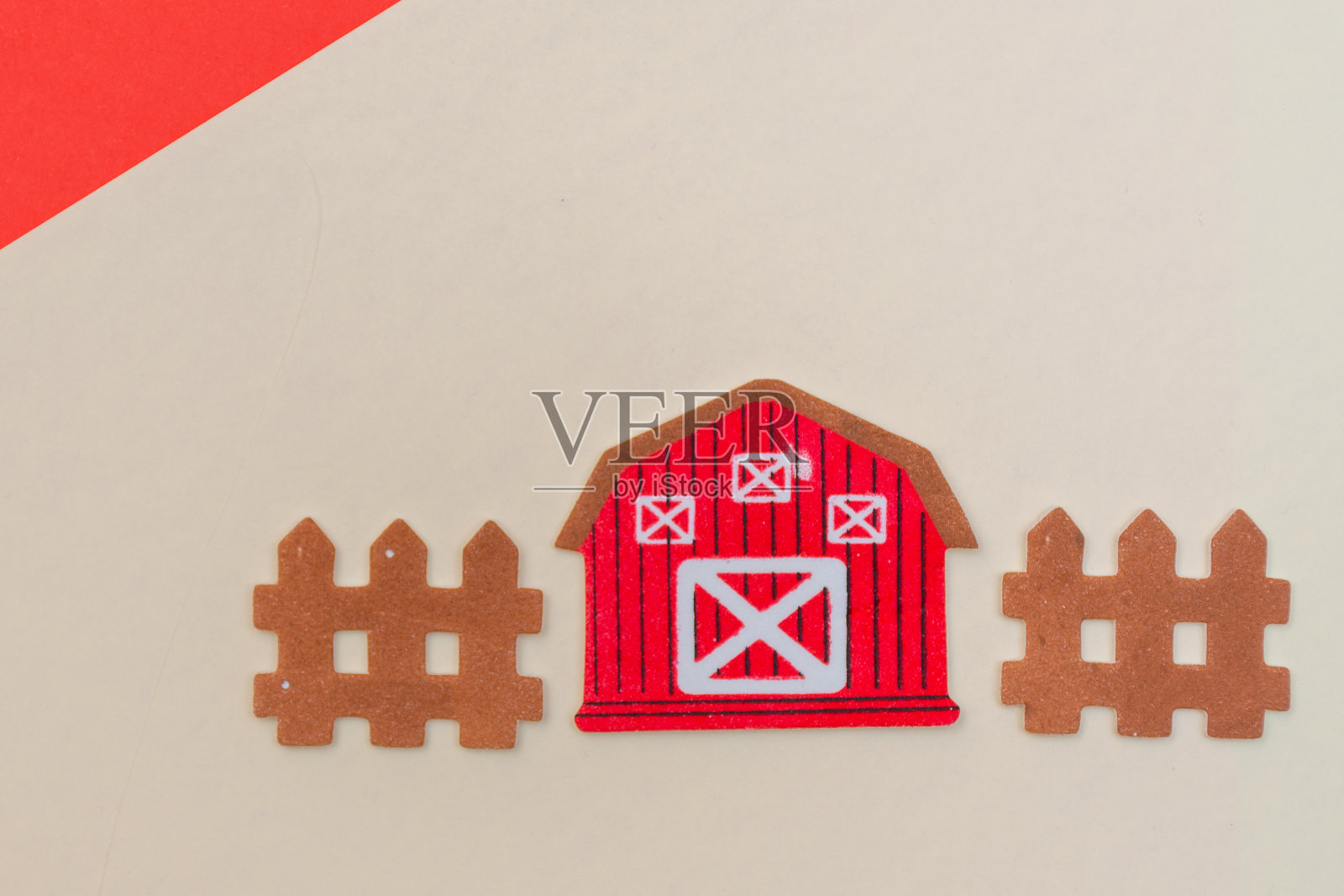 一个红色谷仓和篱笆农场场景的特写，在一个平坦的背景，白色和红色与复印空间可用。照片摄影图片