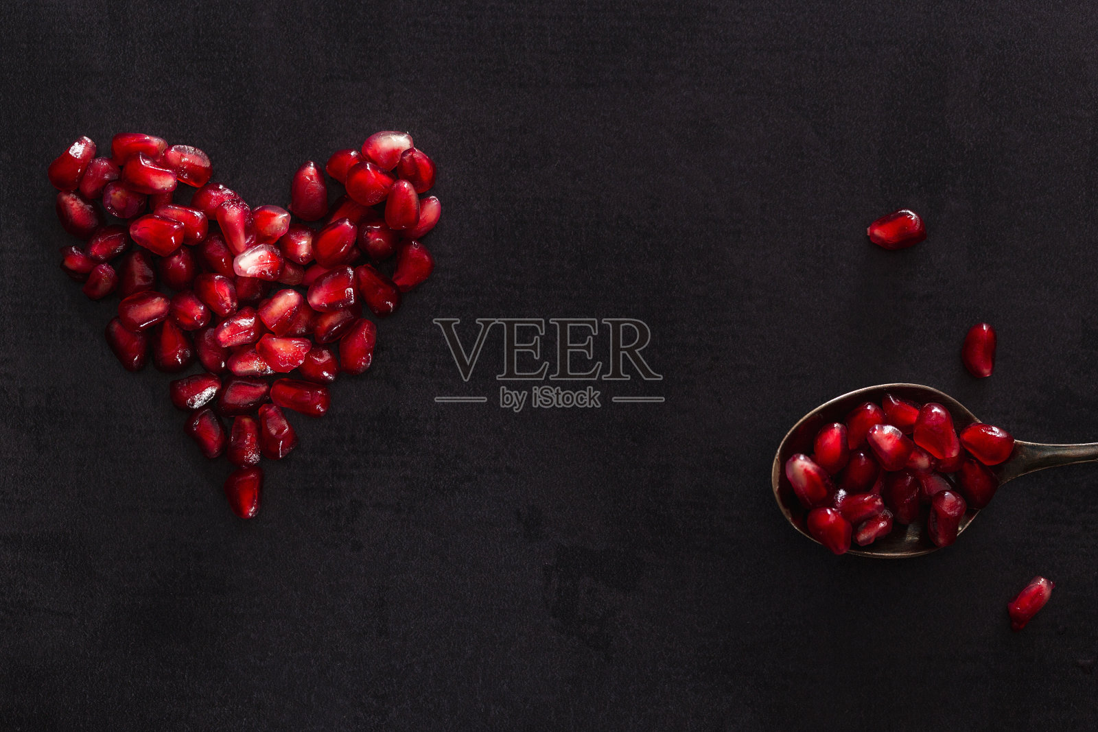 心形的石榴种子在黑暗的风景。照片摄影图片