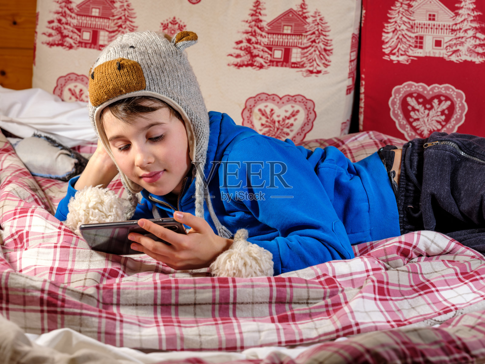 孩子躺在床上用手机发短信照片摄影图片