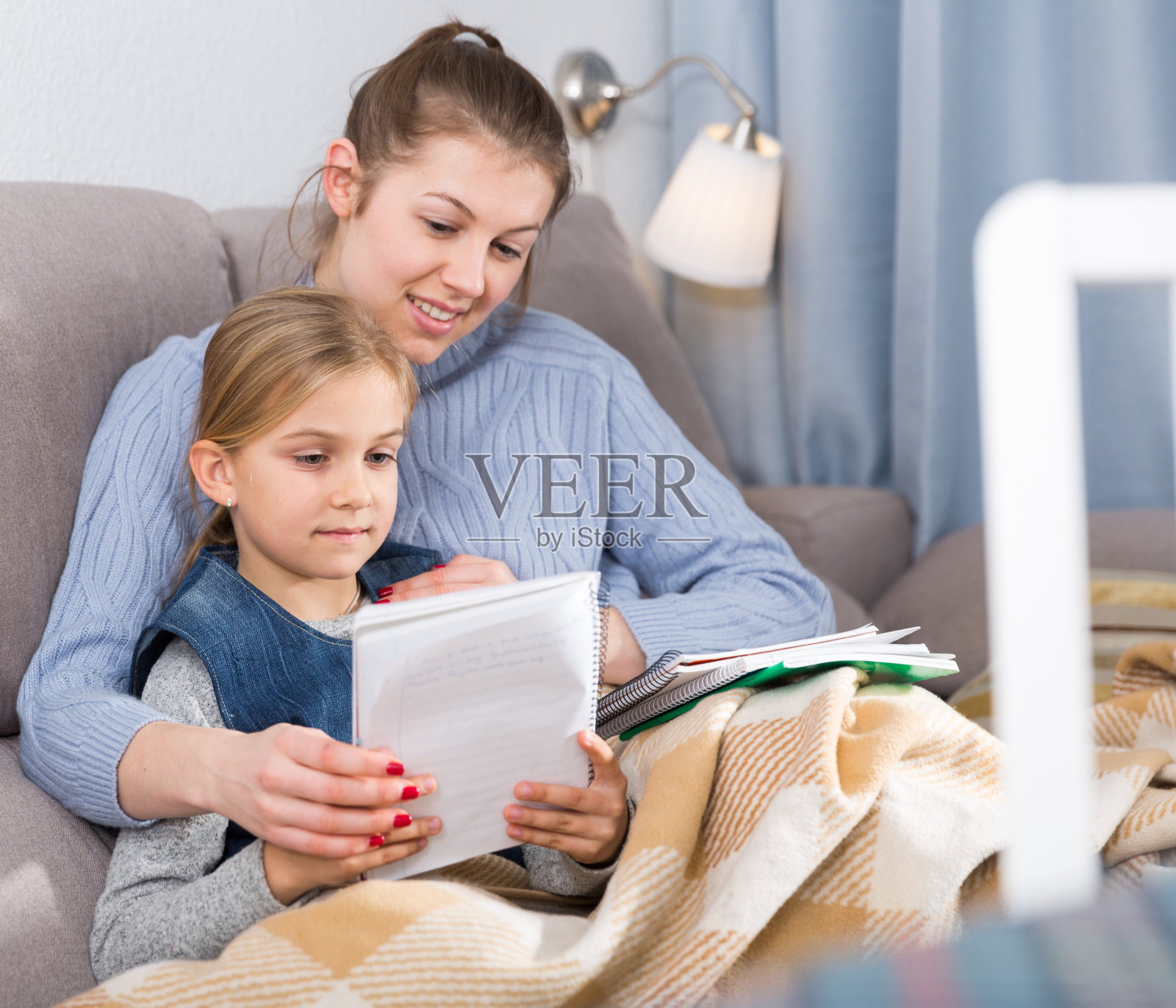 母亲检查学校的课程女儿照片摄影图片