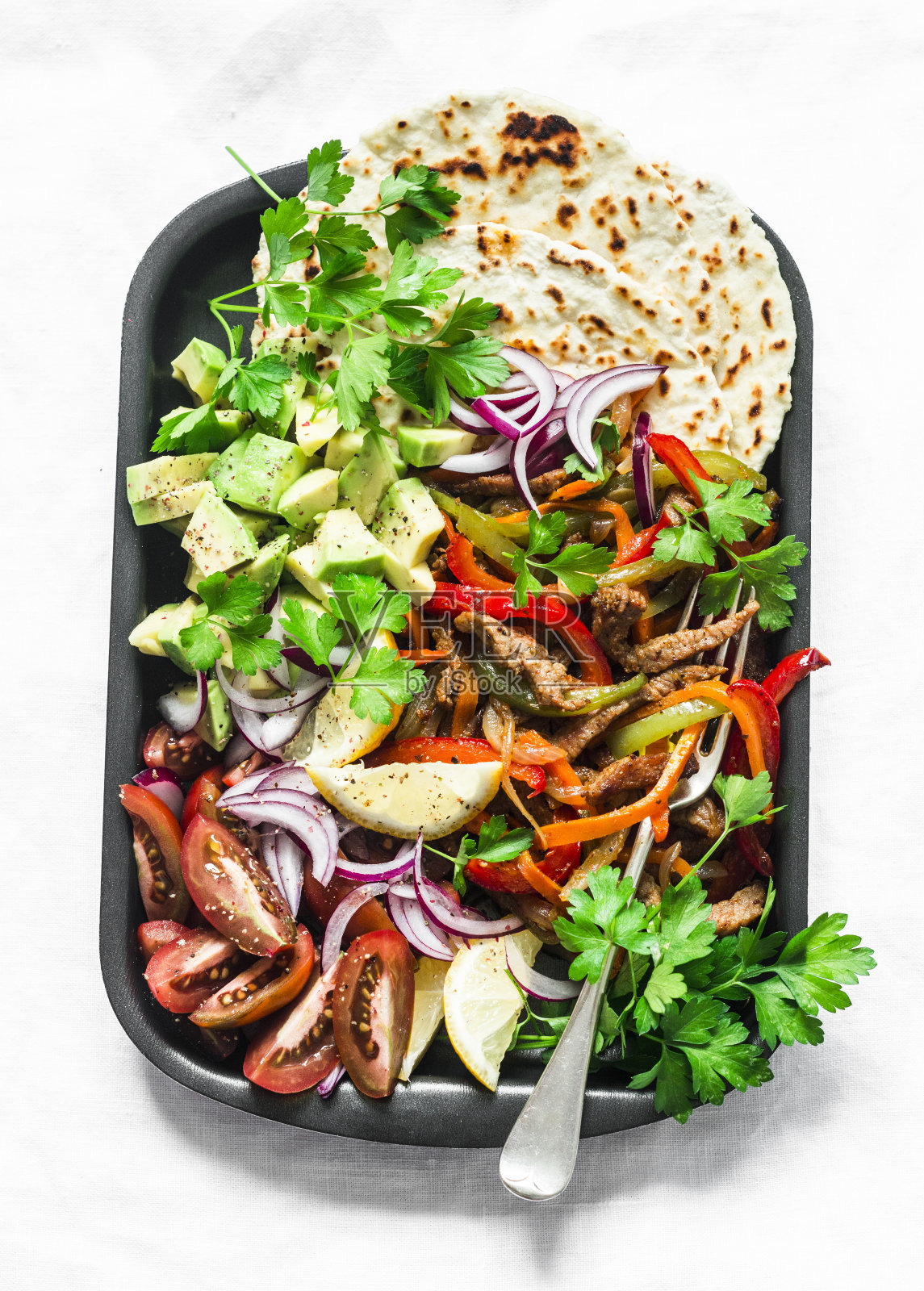 辣味牛肉，蔬菜，鳄梨，玉米饼，墨西哥烙饼在浅背景，俯视图。美味的小吃，墨西哥风味的小吃照片摄影图片