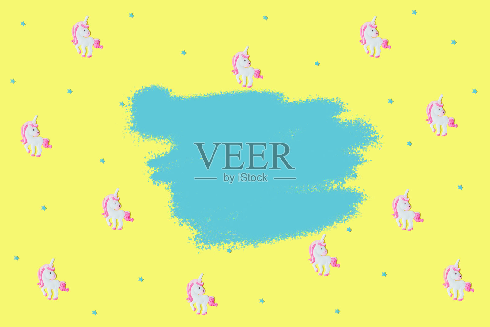 黄色背景下的蓝色星星和粉色独角兽。照片摄影图片