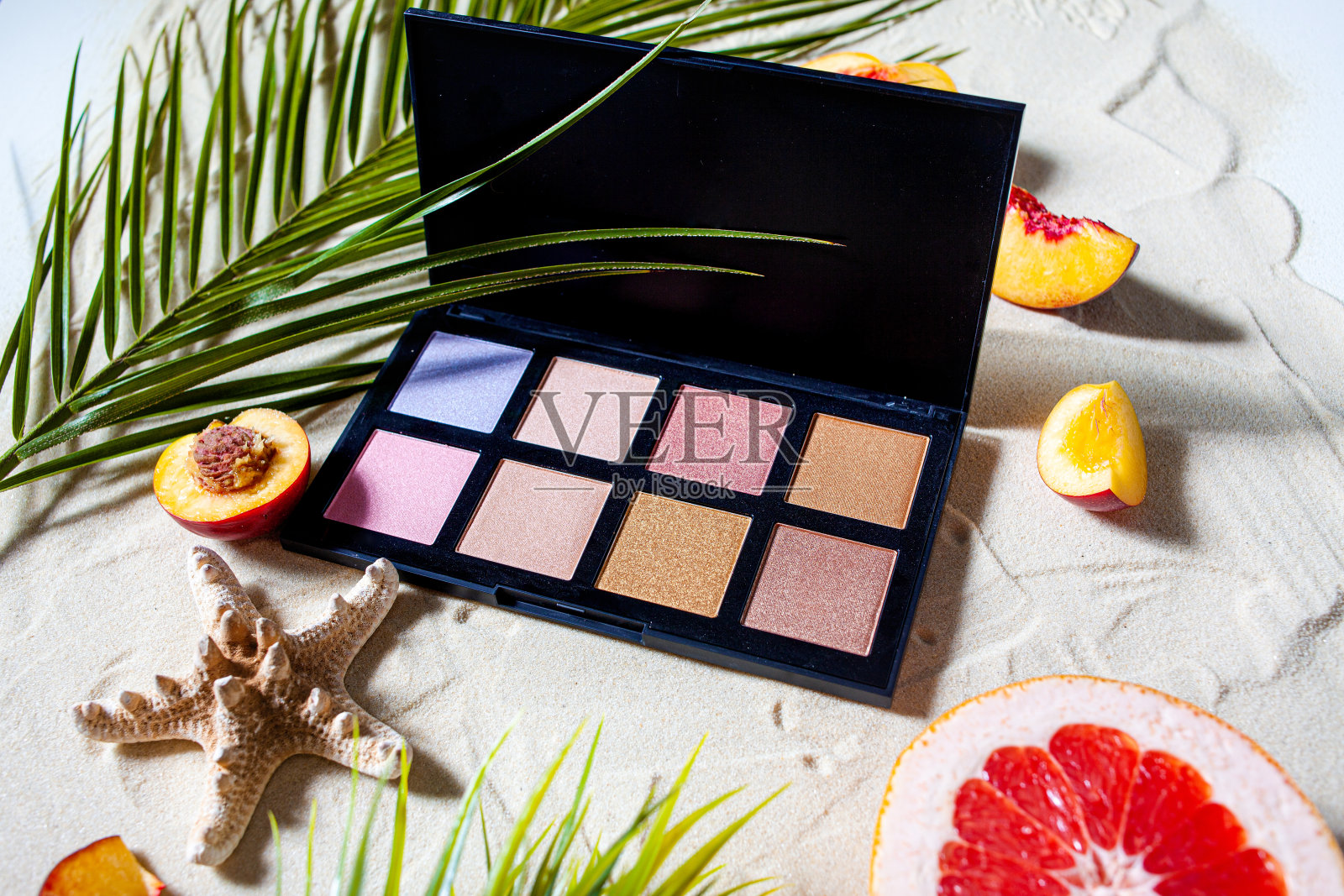 迷人的海滩。色彩斑斓的方形阴影被珊瑚环绕，棕榈树的叶子躺在白色的沙滩上。照片摄影图片