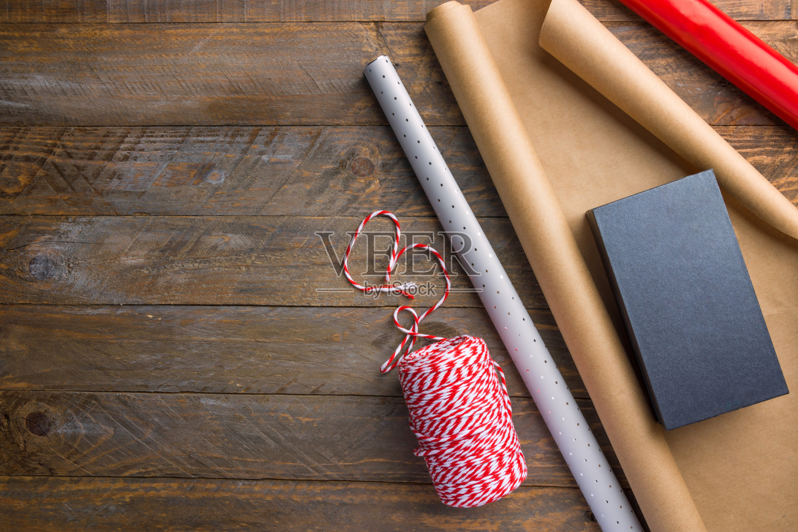 各种棕色、牛皮纸、红色、银色的彩带礼盒放在木桌上。圣诞新年假期礼物采购准备。乡村复古风格舒适的节日气氛照片摄影图片