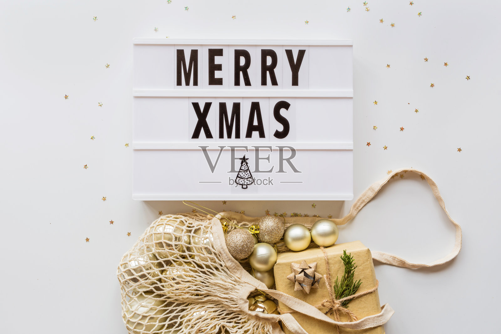 圣诞球在可重复使用的绳袋和五彩纸屑在时尚的白色桌面视图的节日框架。时尚背景。平的。方模型。2020年圣诞节庆祝，新年概念，模板照片摄影图片