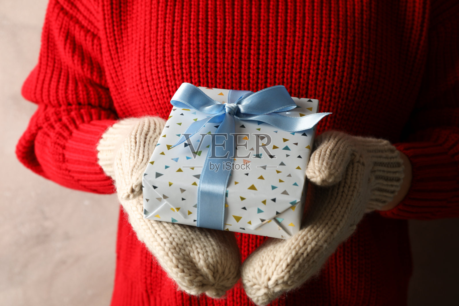 年轻女子拿着带浅蓝色蝴蝶结的礼盒，靠近点照片摄影图片