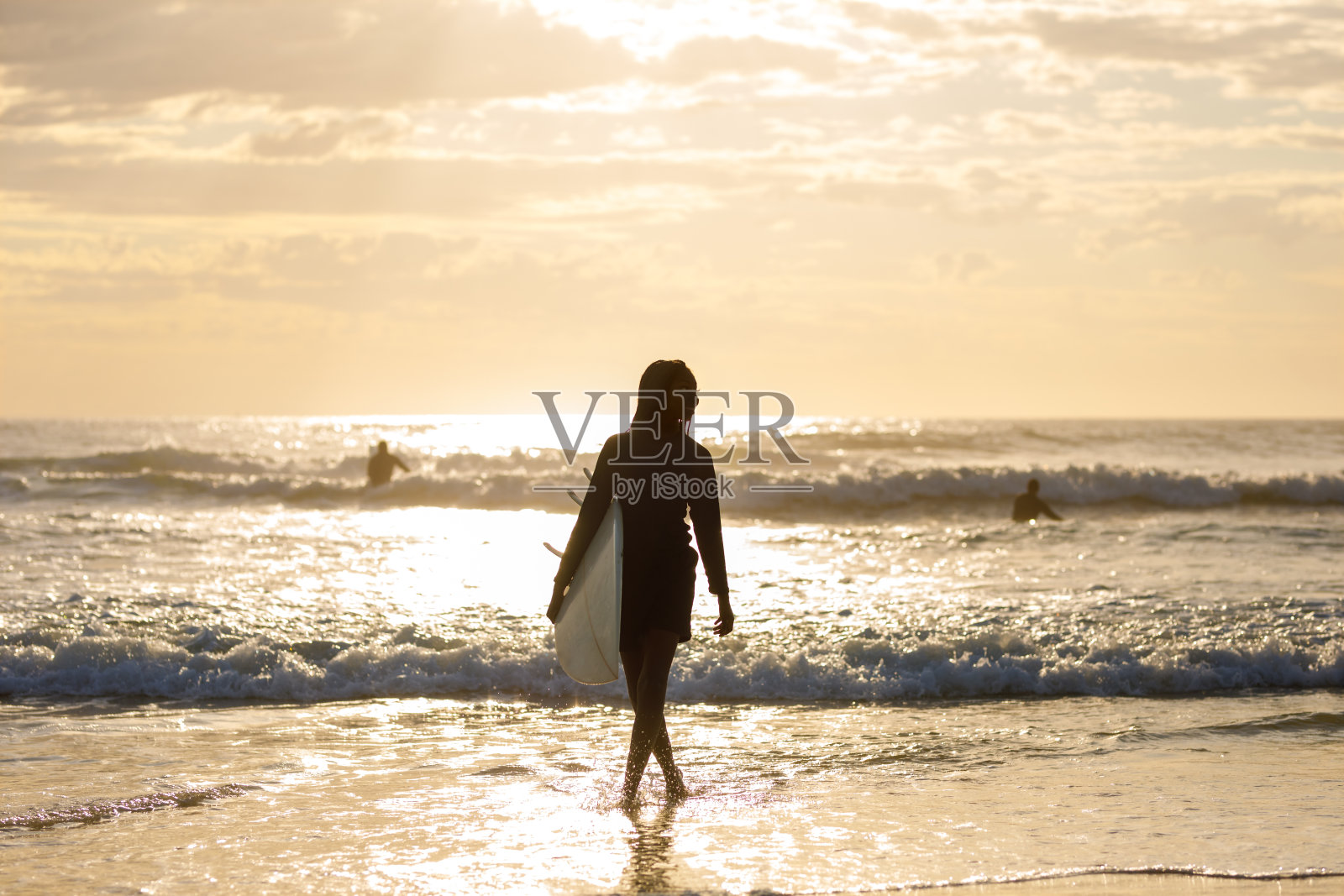 非洲-澳大利亚女冲浪者离开澳大利亚海滩的日出冲浪照片摄影图片