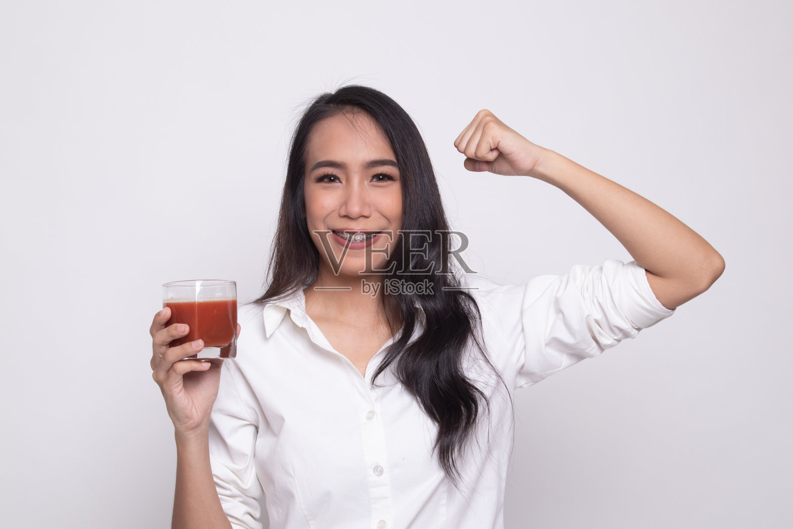 强壮健康的亚洲女人与番茄汁。照片摄影图片