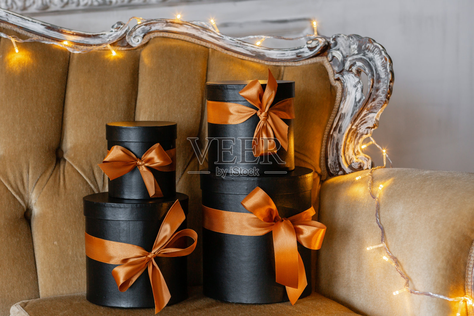 圣诞礼物。扶手椅上有带丝带的黑盒子。照片摄影图片