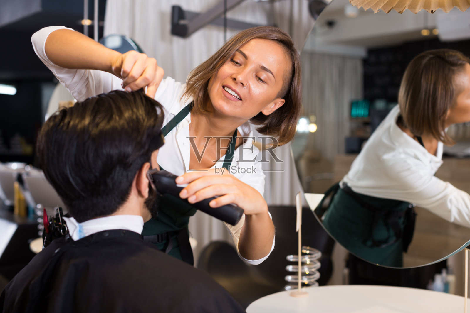 女性专业刮愉快男性的头发照片摄影图片