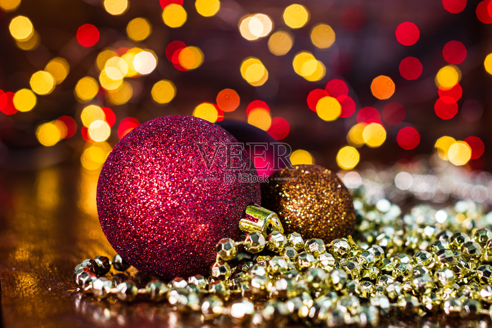 模糊的背景和失去焦点的灯光下的圣诞装饰。闪光圣诞球的特写照片摄影图片