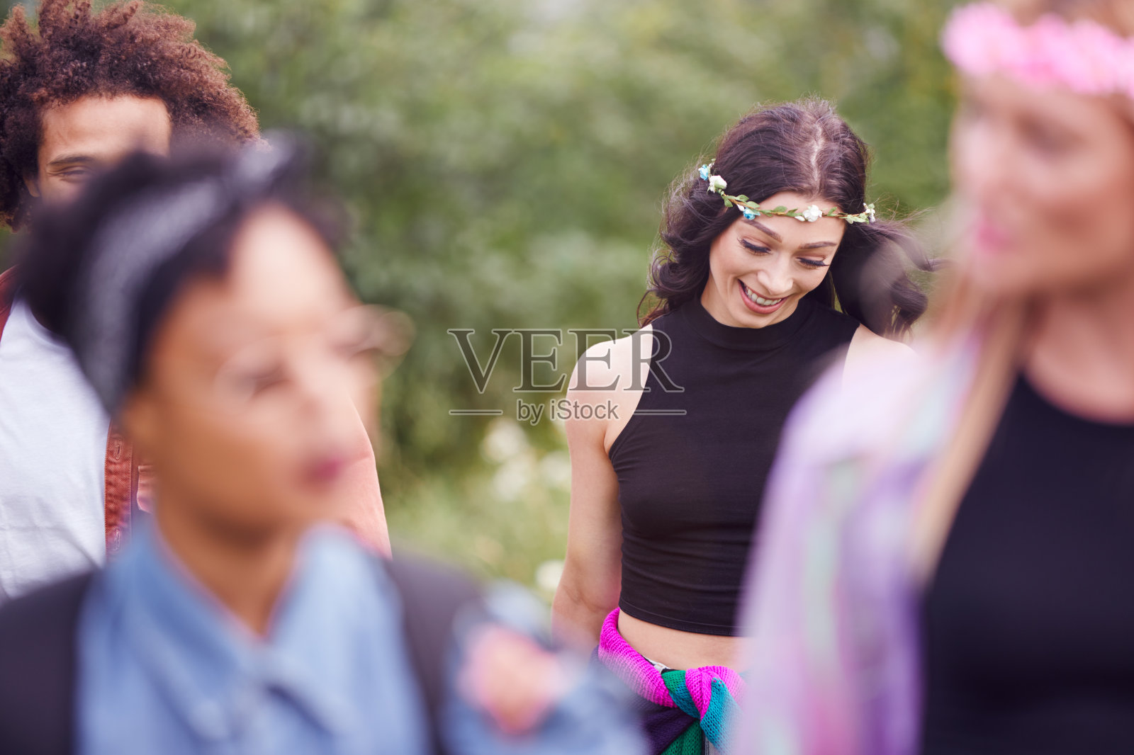 一群兴奋的年轻朋友带着露营装备穿过田野到音乐节照片摄影图片