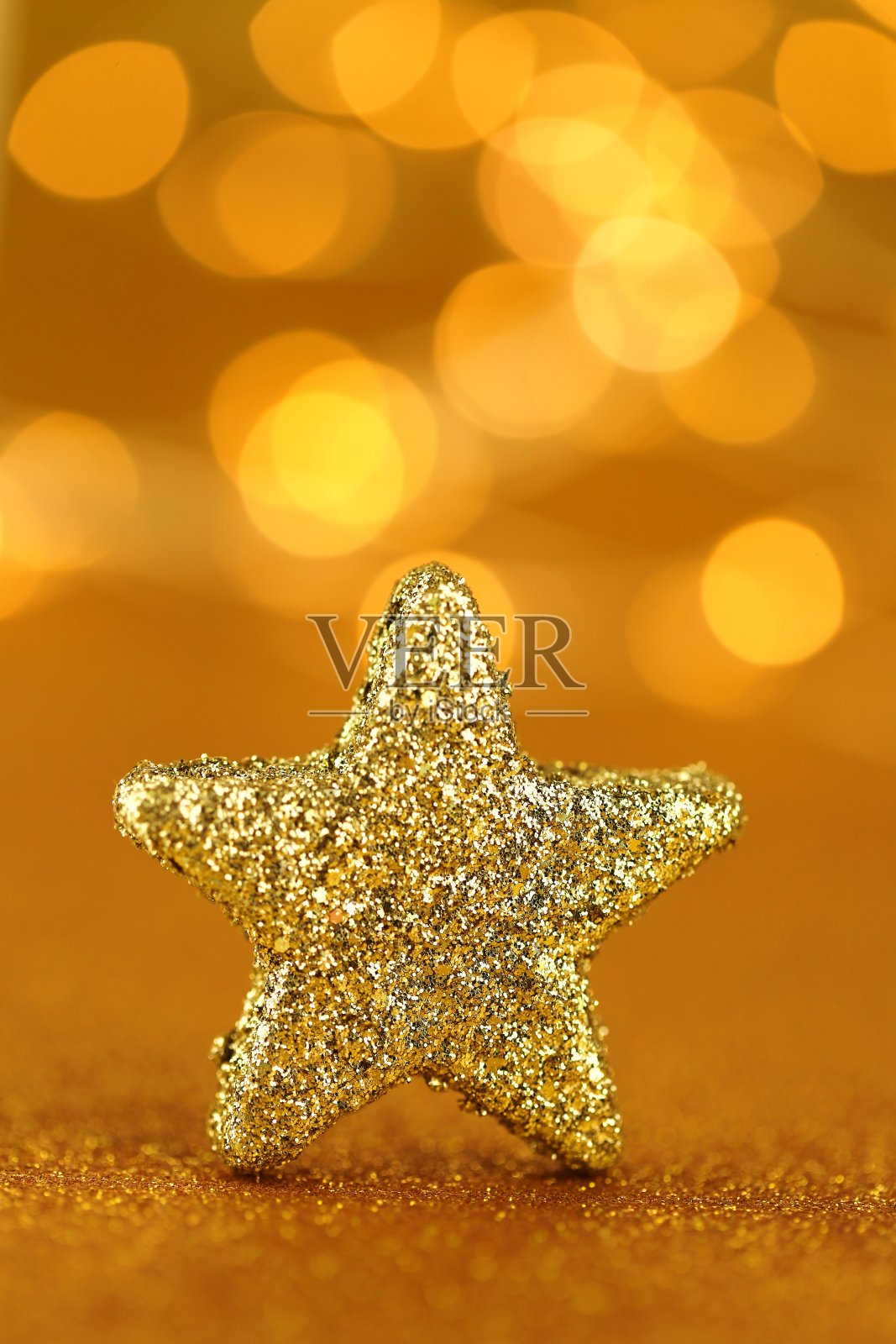 圣诞节日的背景。金色闪光星在金色闪亮的背景与黄色闪光散焦。圣诞节和新年的背景。寒假墙纸。金色闪亮的壁纸。照片摄影图片