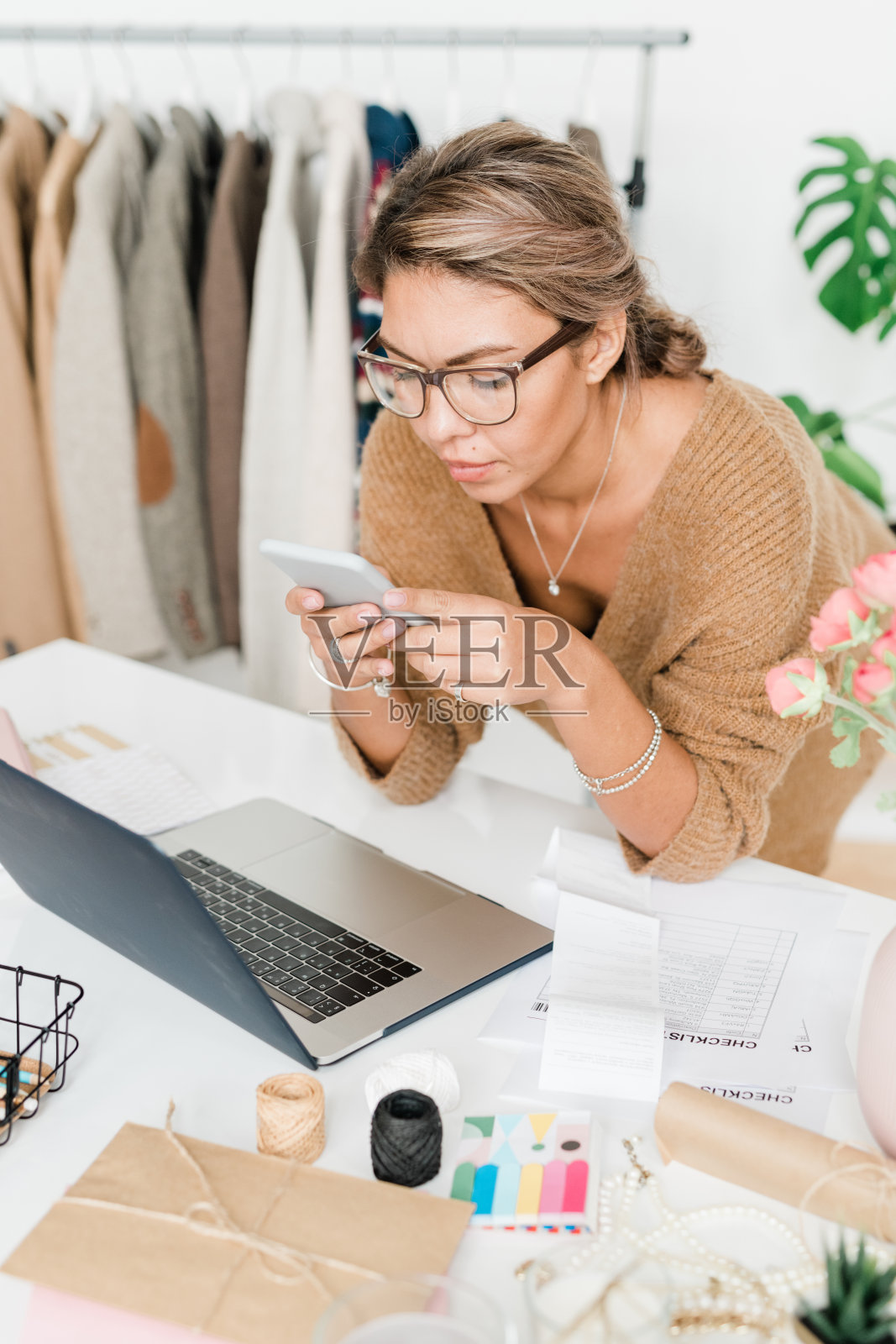 漂亮的年轻休闲店员现代精品店弯腰工作照片摄影图片