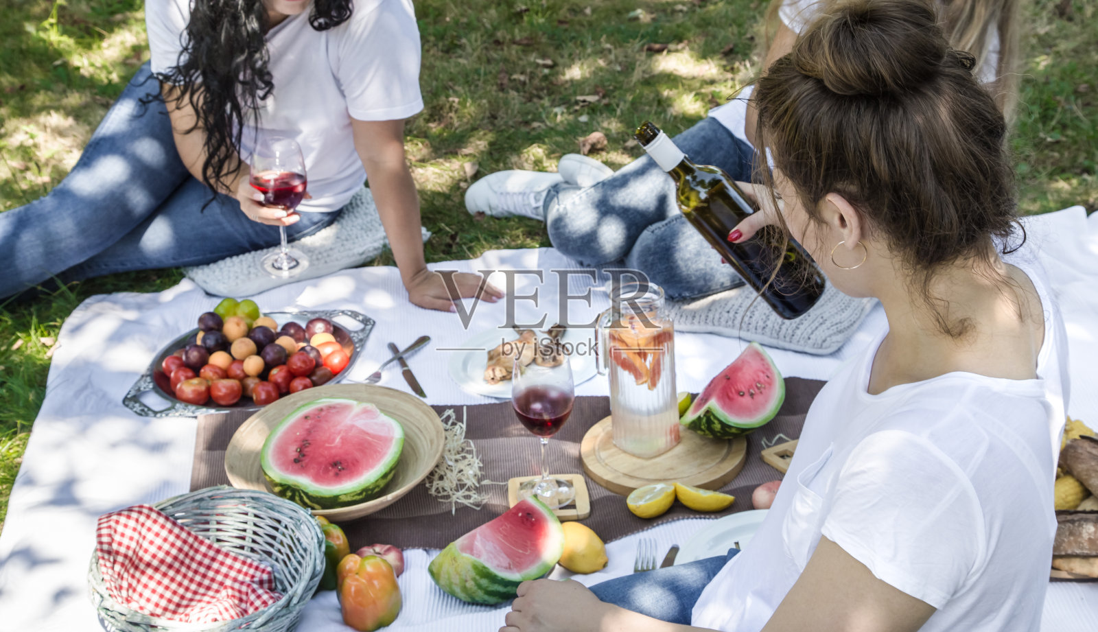 夏天与朋友们在大自然中野餐，带着食物和饮料。照片摄影图片