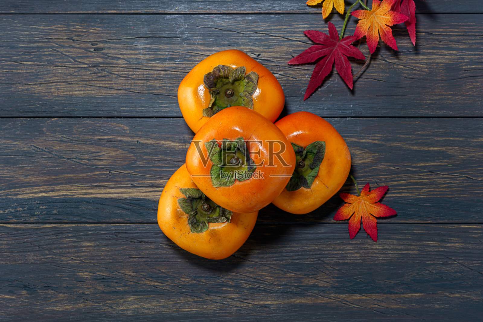 新鲜成熟的柿子放在木桌上照片摄影图片