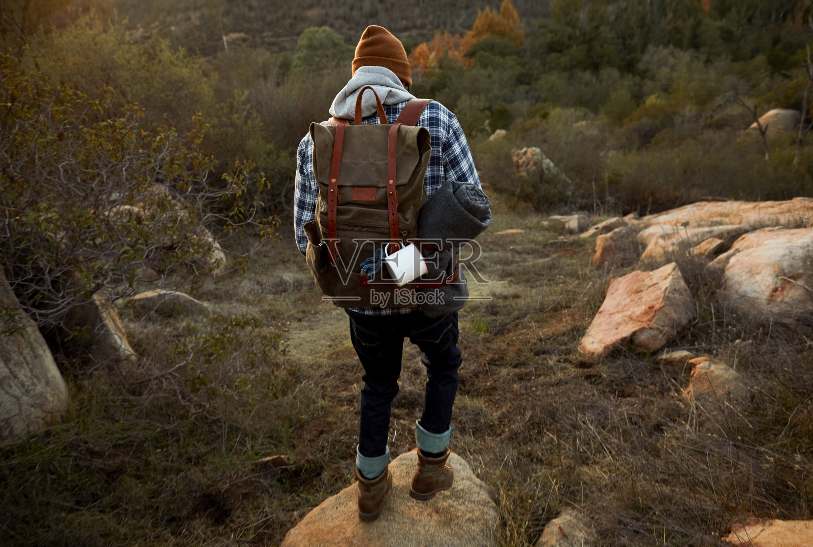 年轻人在黎明时沿着岩石小径徒步照片摄影图片