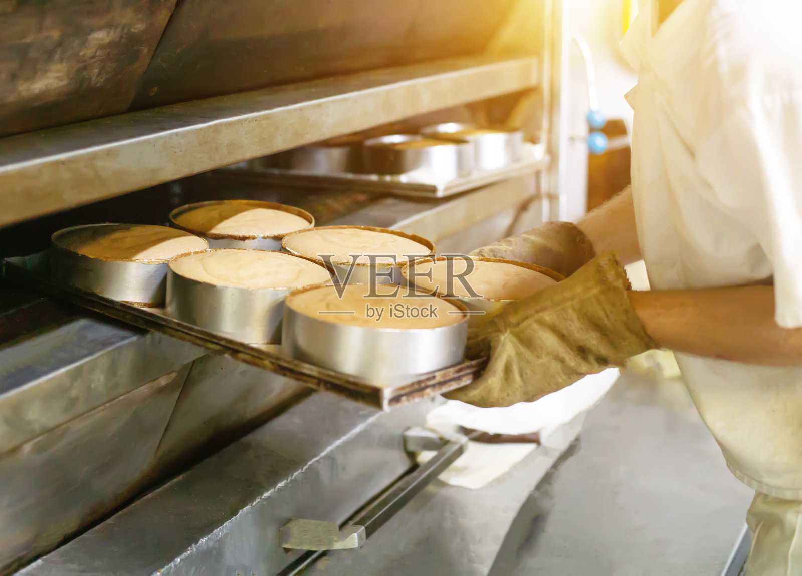 男厨师将蛋糕从热烤箱中取出，制作蛋糕，工业照片摄影图片