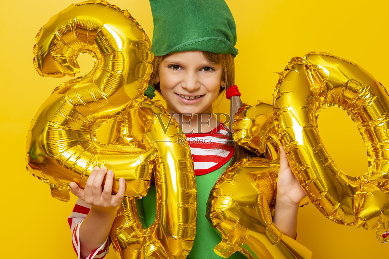 穿着精灵服装的孩子拿着2020年的气球照片摄影图片