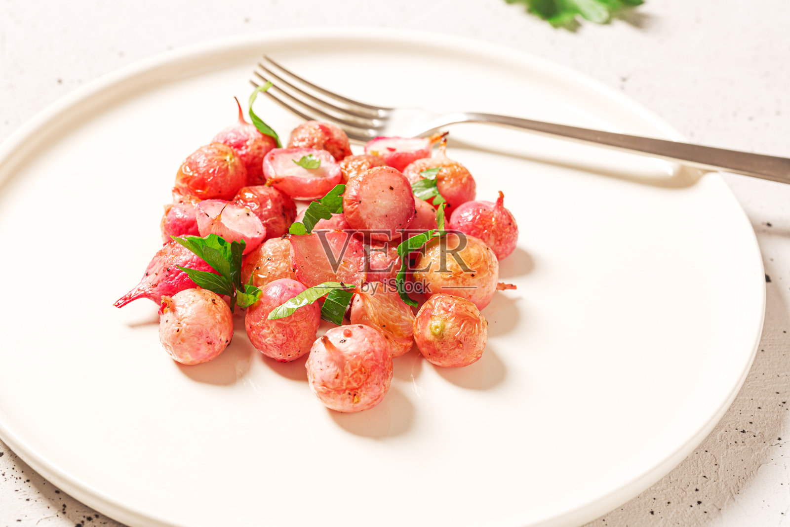 美丽的烤萝卜在一个白色的盘子在混凝土背景，近。照片摄影图片