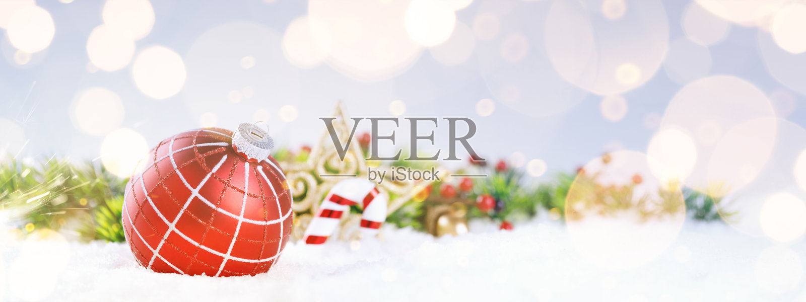 红色装饰球在圣诞树上闪闪发光的散景背景与金色闪烁的灯。照片摄影图片