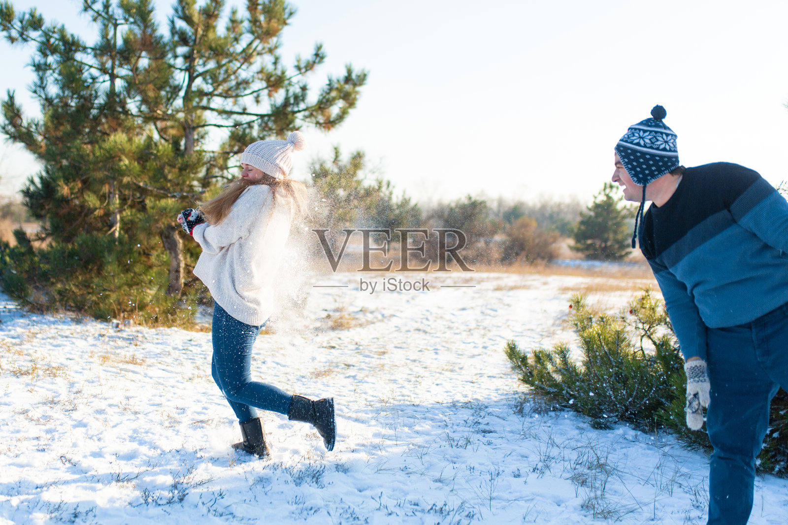 情侣们冬天在森林里打雪仗。互相扔雪。开怀大笑，享受美好时光照片摄影图片