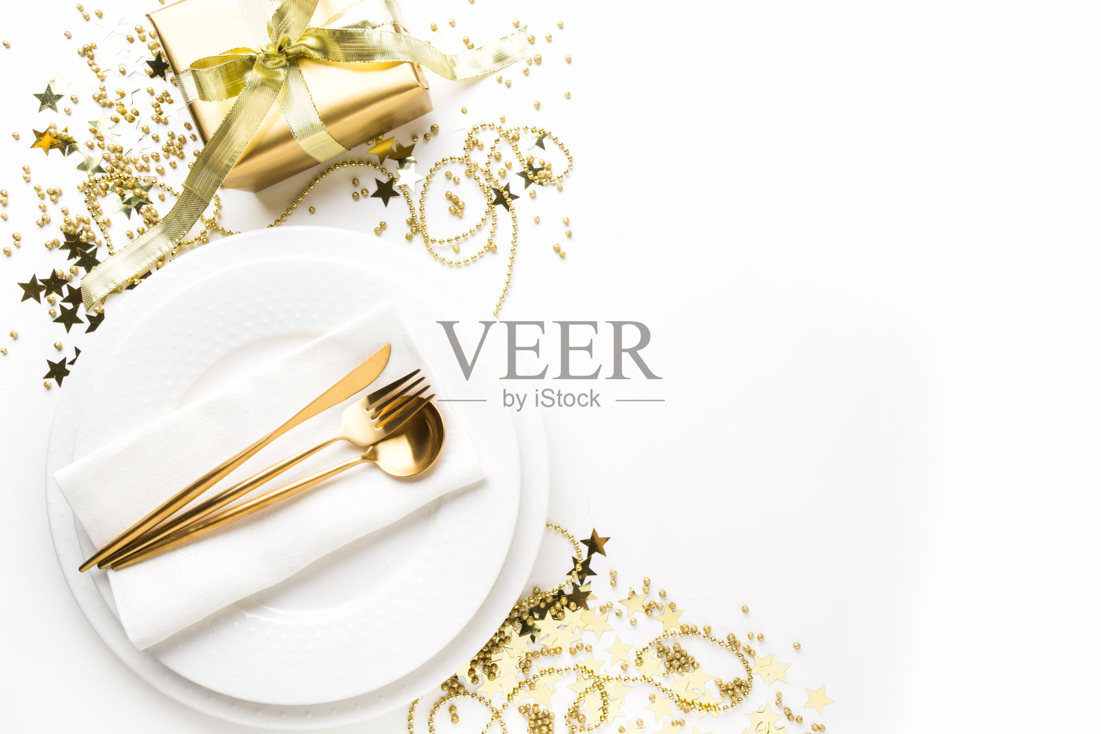 圣诞餐桌上的餐具，金色银器在白色的背景。前视图。照片摄影图片