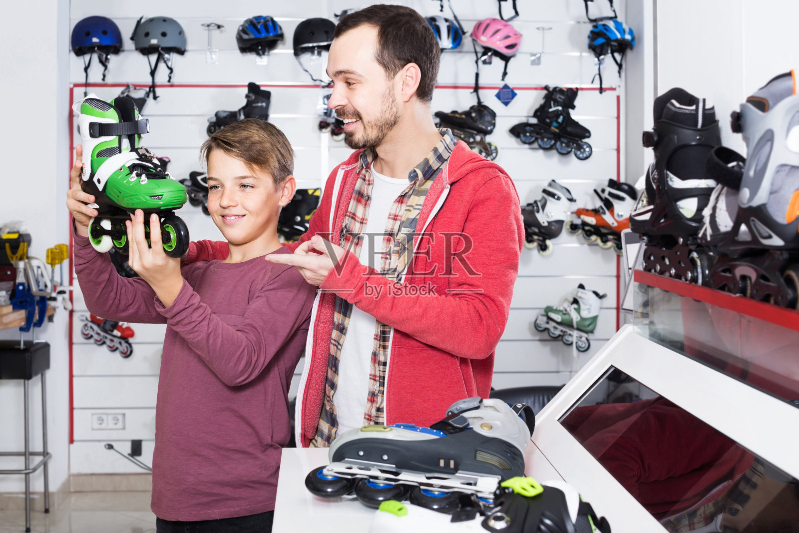 父亲和儿子决定在运动商店买一双新的旱冰鞋照片摄影图片