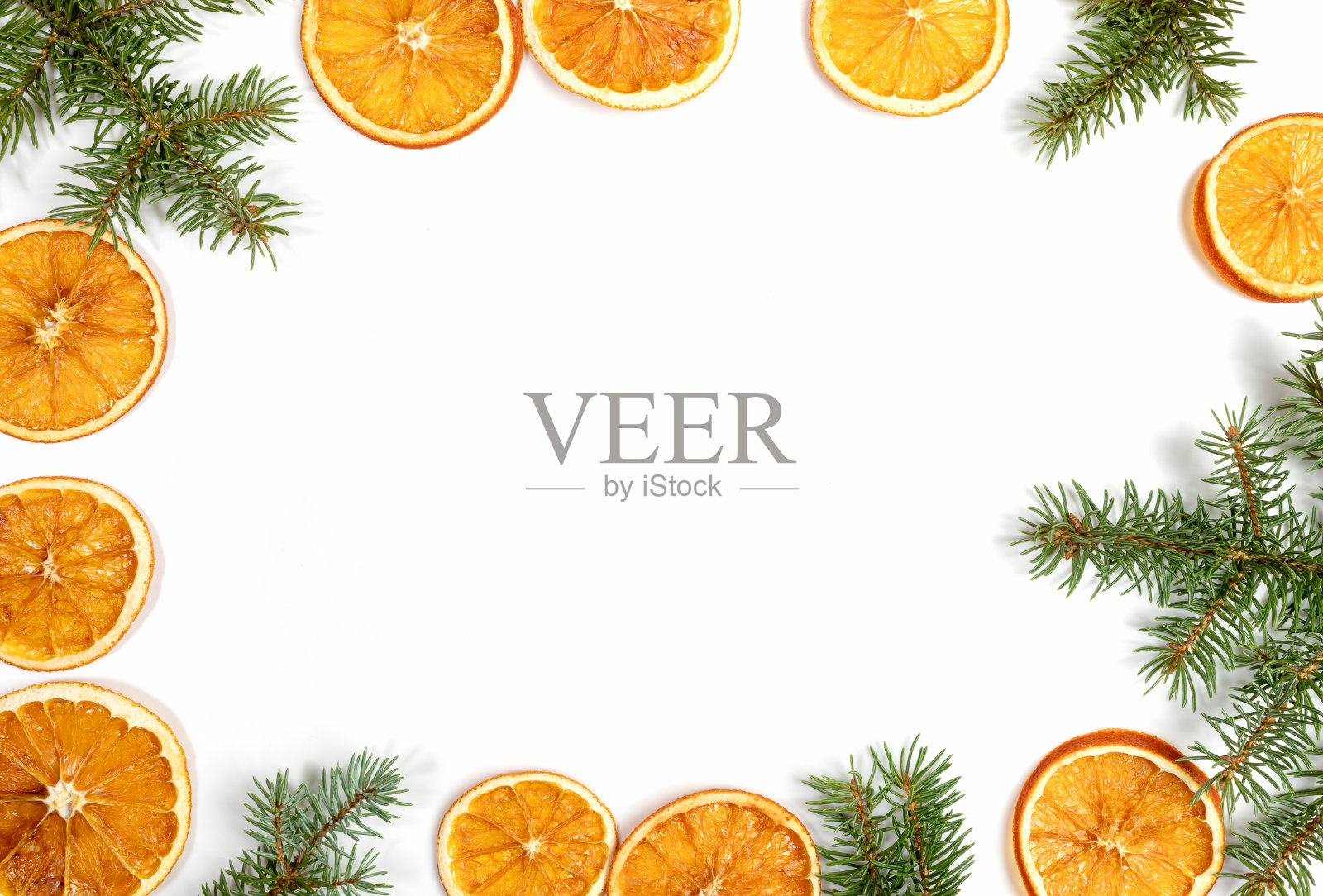 框架的绿色冷杉树枝和干橙子片孤立在白色的背景。俯视图，平放，复制空间。照片摄影图片