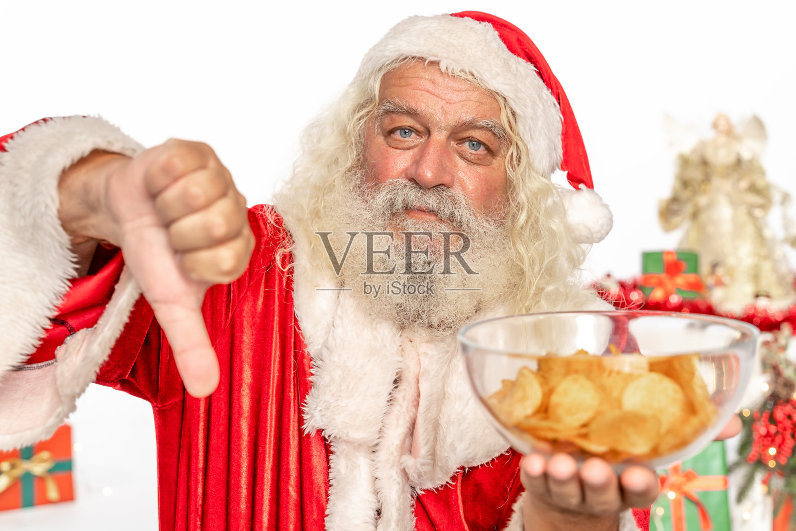圣诞老人对不健康的饮食和薯片做拇指向下的手势照片摄影图片