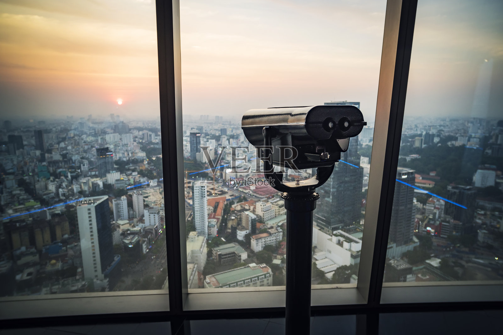 双筒望远镜或望远镜在摩天大楼顶部观察。从摩天大楼顶部观光的装置。西贡或胡志明市。越南。照片摄影图片