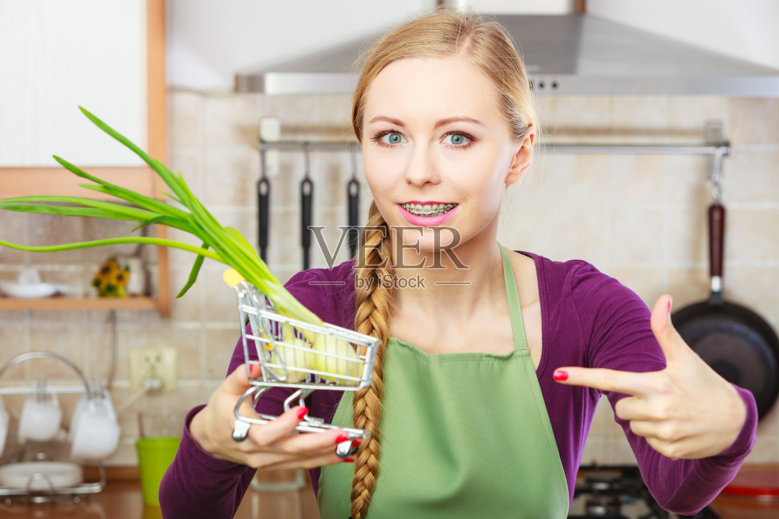 女人推着购物车，里面放着韭菜照片摄影图片