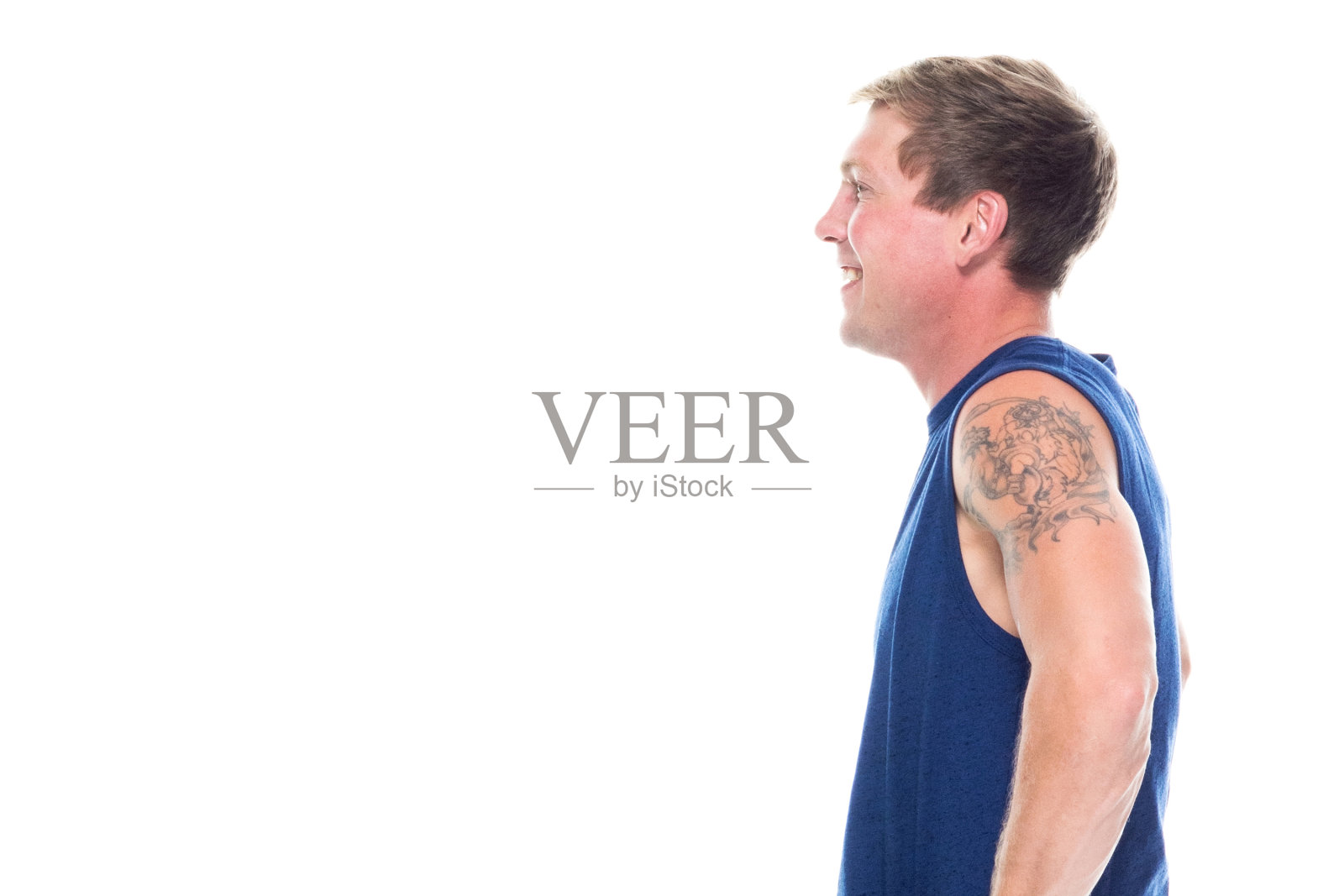 全长/侧视图/侧面视图/一人只/一人20-29岁的成年英俊的人白人男性/年轻男子无袖坐/休息穿着背心/牛仔裤/裤子/帆布鞋/酷的态度与手放在臀部照片摄影图片