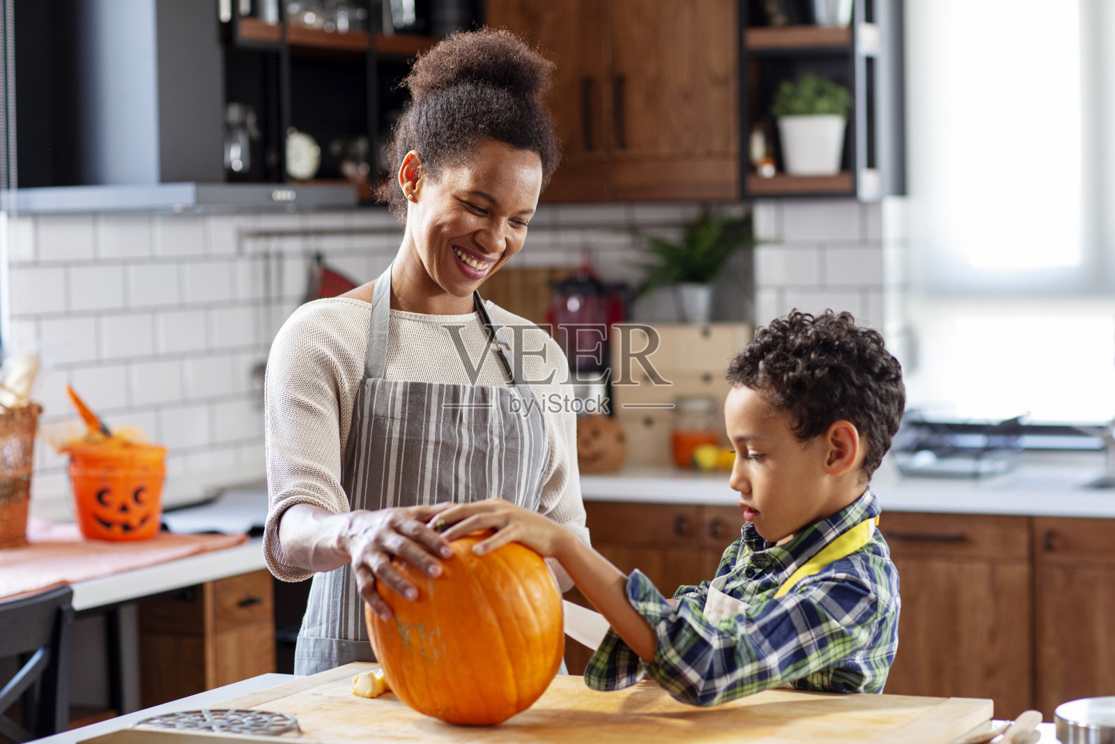 女人和他的儿子在厨房为万圣节准备南瓜照片摄影图片