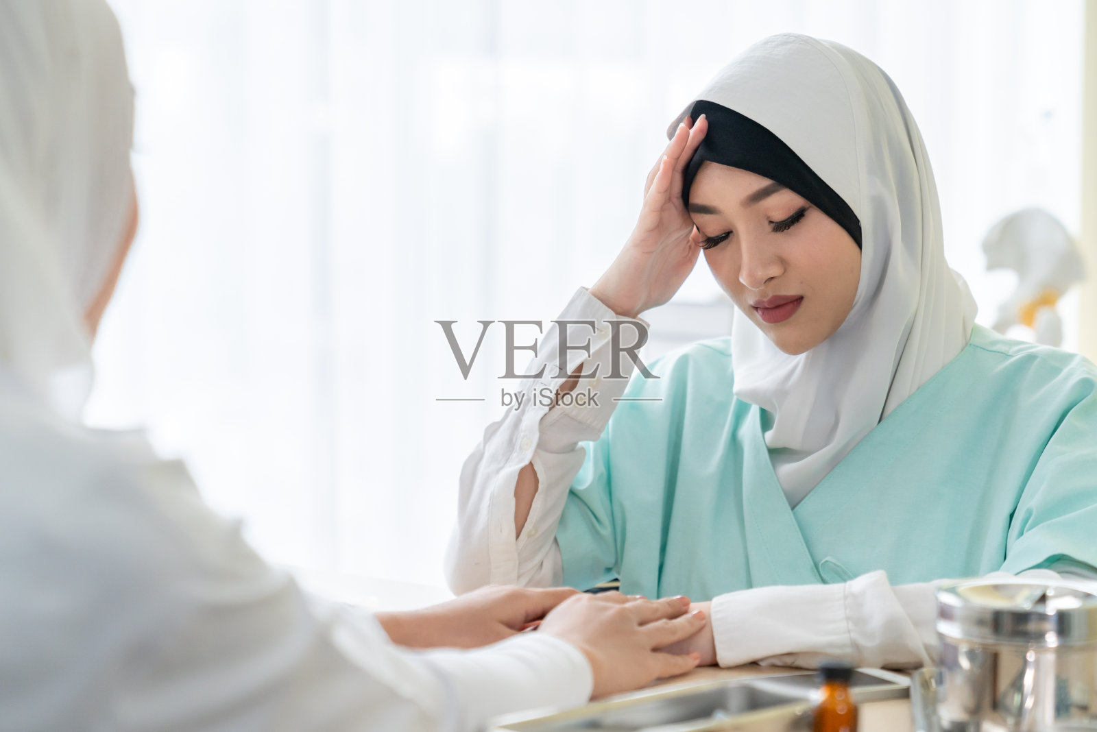 女穆斯林病人告诉女穆斯林医生头痛失眠和抑郁的症状影响身体照片摄影图片