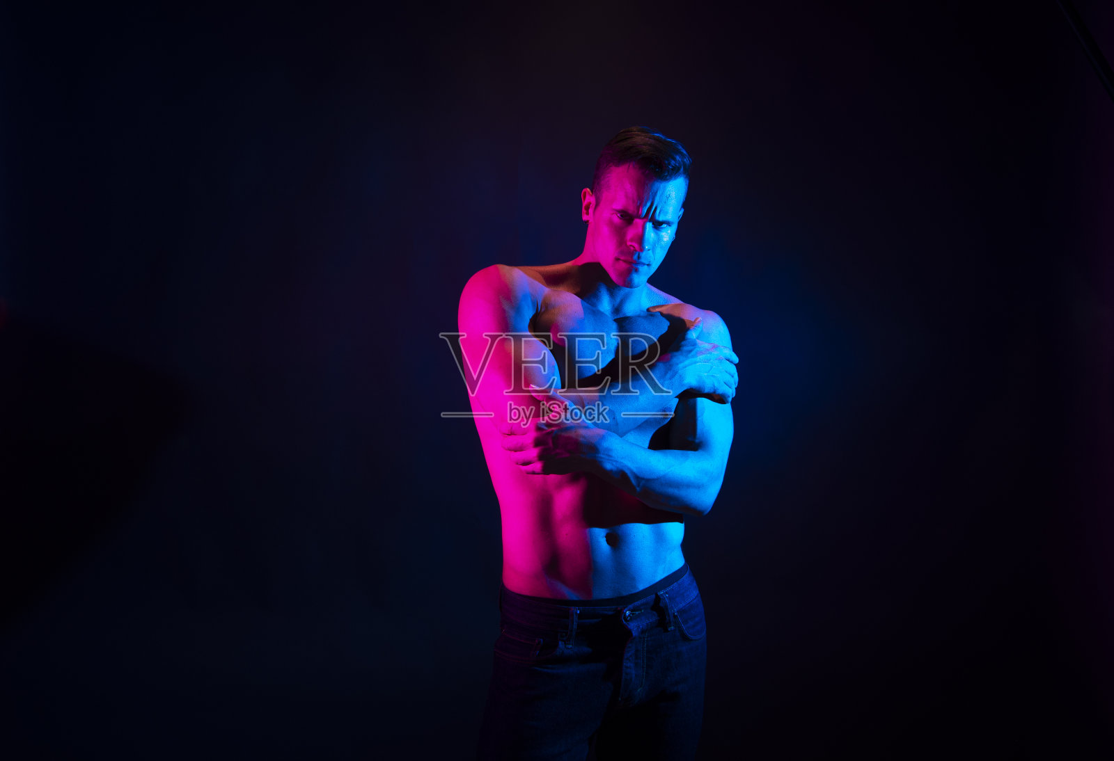 腰部以上/一名男子仅/一个20-29岁英俊的人白人男性/年轻男子站在黑人背景/多色背景/彩色背景穿着牛仔裤谁是肌肉健全人/一个性感的象征/赤膊照片摄影图片